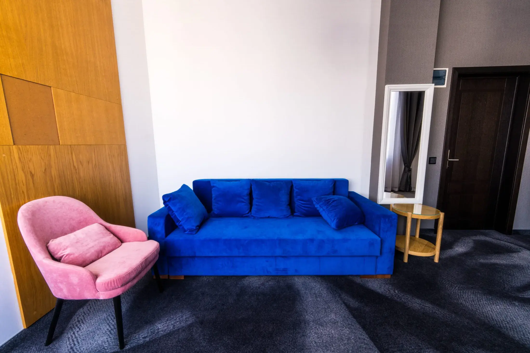 Canapea de catifea albastră și fotoliu roz în apartament