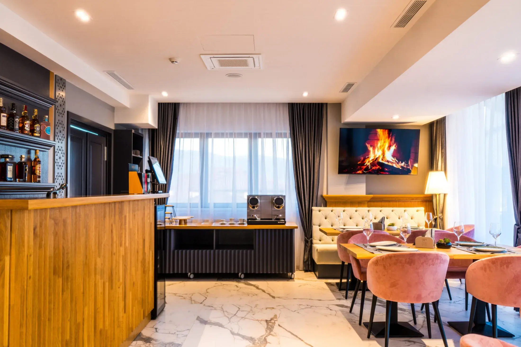 Sala restaurantului cu bar din lemn, ferestre mari și mese puse