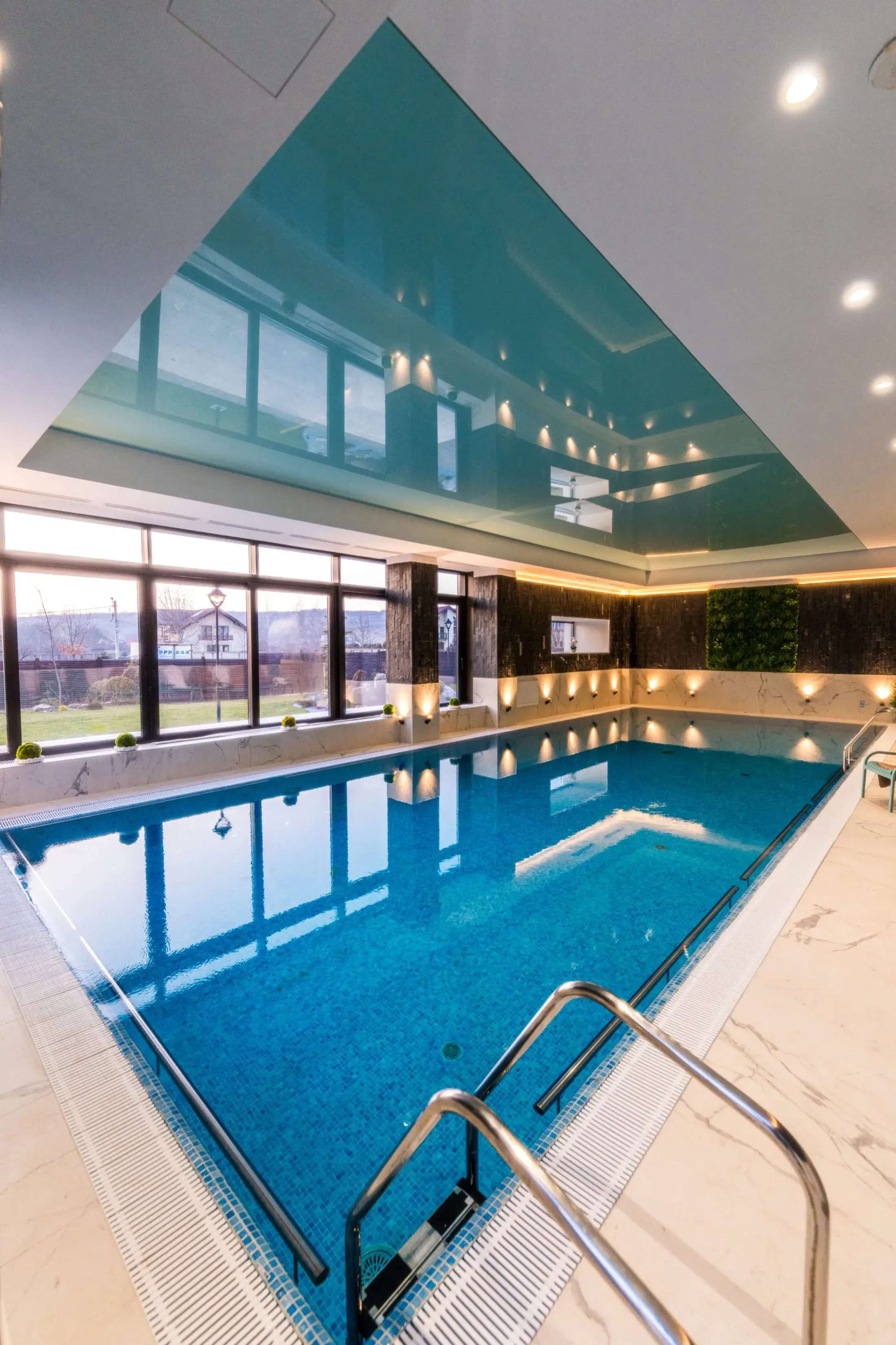 Piscina văzută pe verticală, cu scara de acces din oțel în prim-plan