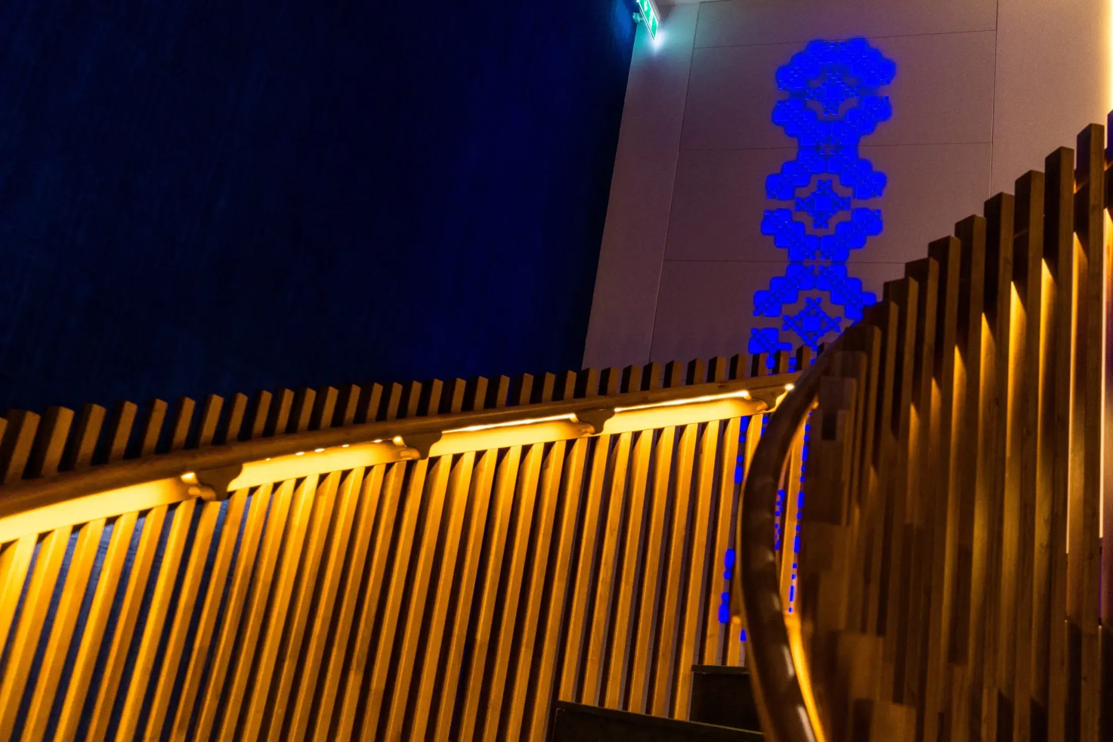 Balustrada de stejar luminată, sub un perete albastru